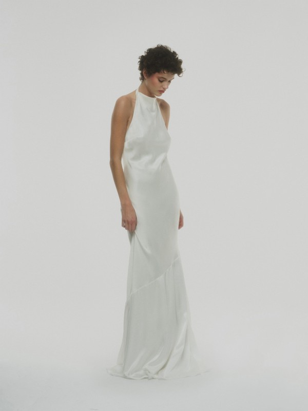 Schlichtes Neckholder Brautkleid aus sanft glänzendem Satin mit fließender Silhouette im Studio