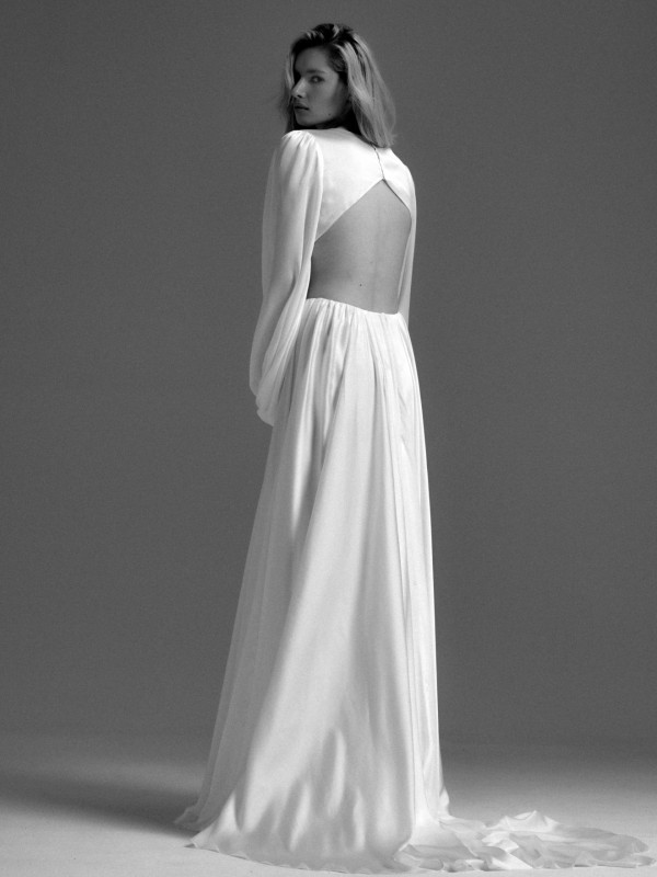 Rückenfreies Brautkleid mit langen transparenten Ärmeln und Keyhole Öffnung im Rücken sowie fließendem Rock im Studio