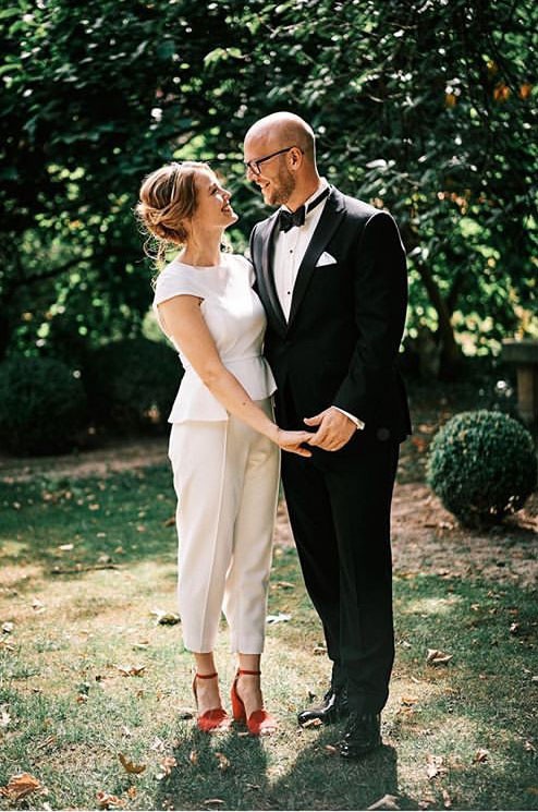 Moderne Braut im weißen Jumpsuit – Real Bride Mandy bei ihrer Outdoor-Hochzeit mit Bräutigam Georg. Eleganter und individueller Hochzeitsstil, fotografiert von Jan von Allwörden. Styling: Ria Saage, Blumen: Milles Fleurs.